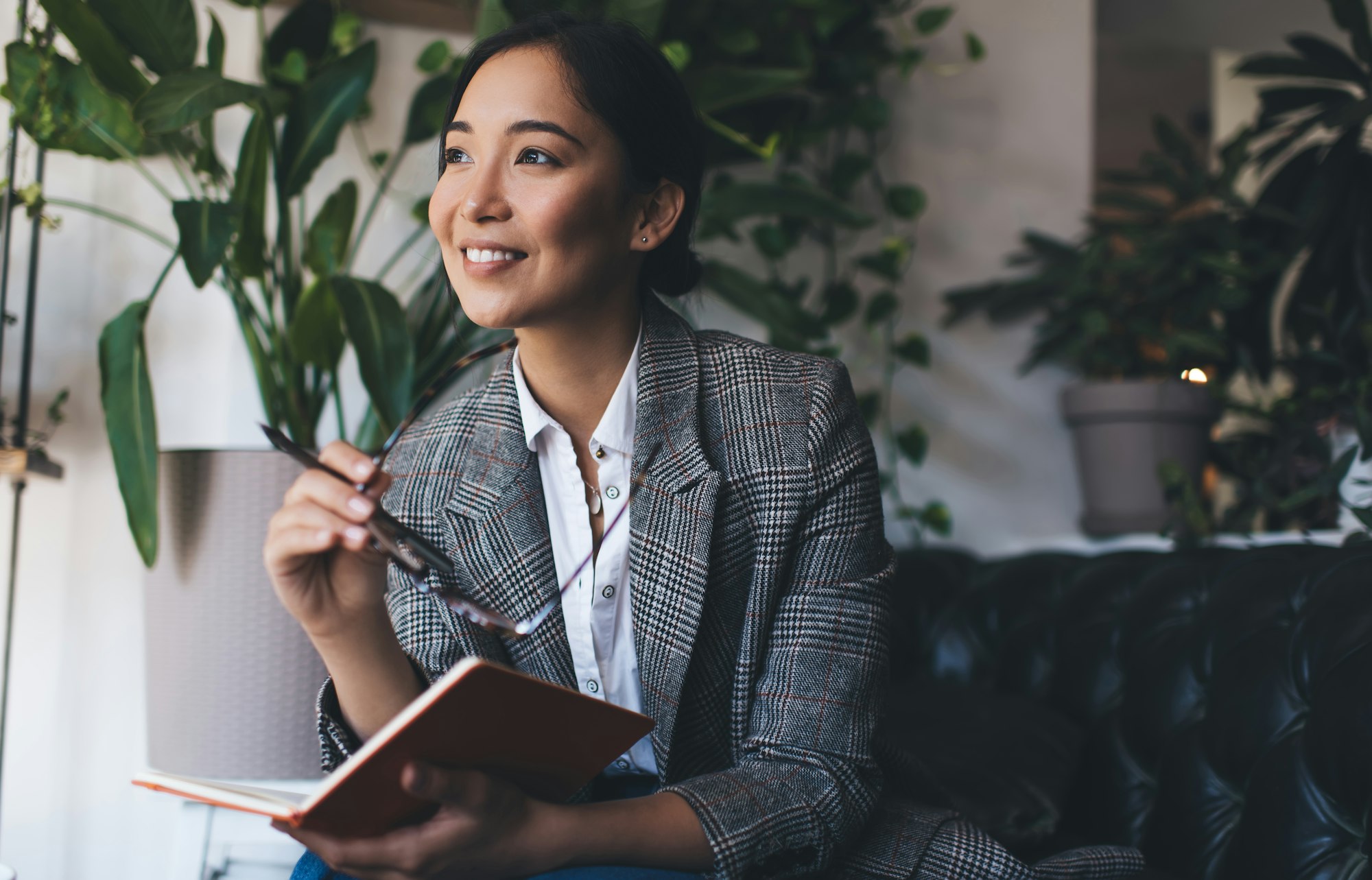 , happy Asian journalist with notepad planning